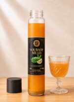 Bottle of Farm Fresh Grocery Soursop Mead, a naturally fermented honey wine, served next to a full wine glass